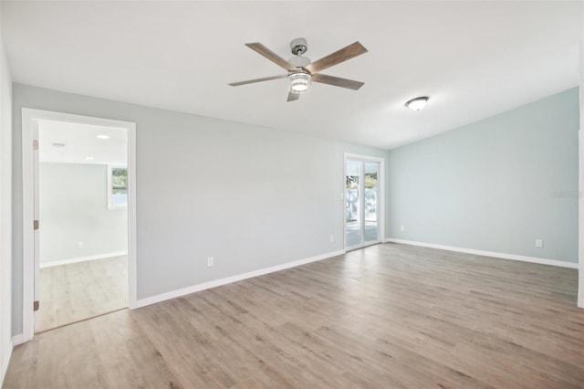 empty room featuring plenty of natural light, ceiling fan, and light wood-type flooring