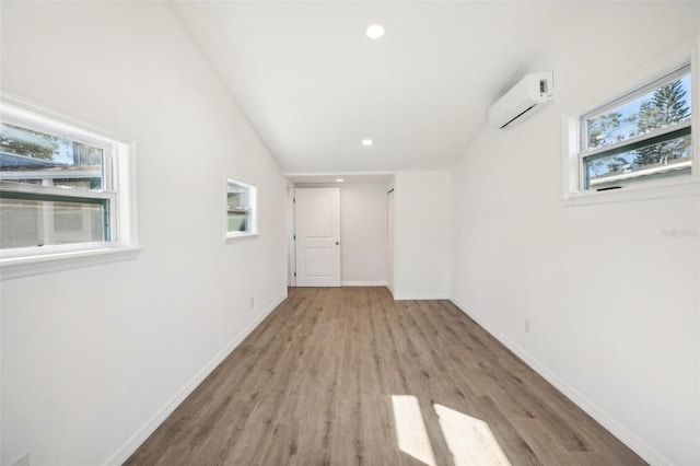 interior space featuring a wealth of natural light, light hardwood / wood-style floors, and a wall mounted air conditioner