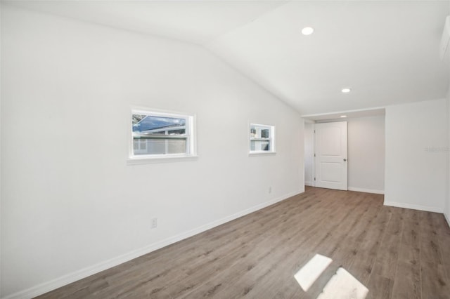 additional living space featuring light hardwood / wood-style flooring and vaulted ceiling