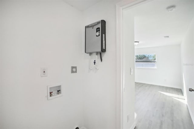 laundry area featuring electric dryer hookup, hookup for a washing machine, and hardwood / wood-style floors