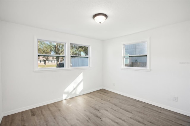 unfurnished room with hardwood / wood-style flooring