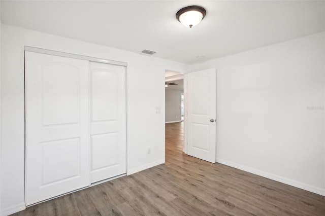 unfurnished bedroom featuring a closet and hardwood / wood-style flooring