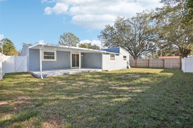 back of house with a yard and a patio area