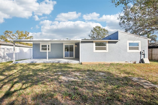 rear view of property featuring a patio and a lawn