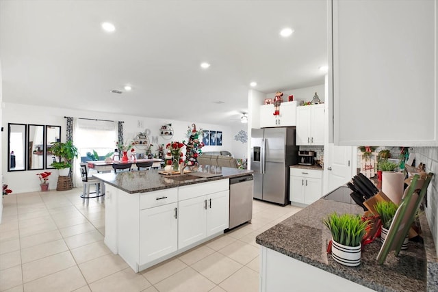 kitchen with stainless steel appliances, dark stone countertops, and light tile patterned flooring