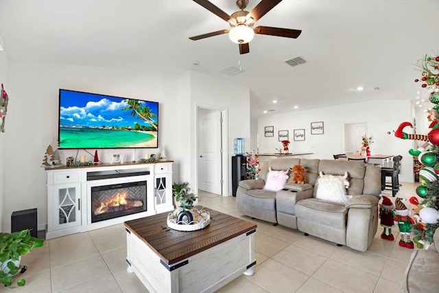 living area with light tile patterned floors, recessed lighting, visible vents, a ceiling fan, and a glass covered fireplace