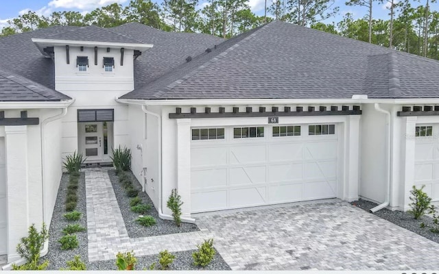 11 Regency Rd, Ormond Beach, FL 32174 - view of front of property featuring a shingled roof, a garage, driveway, and stucco siding