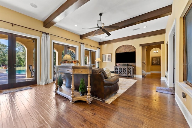 living room featuring ceiling fan, french doors, beamed ceiling, and wood-type flooring