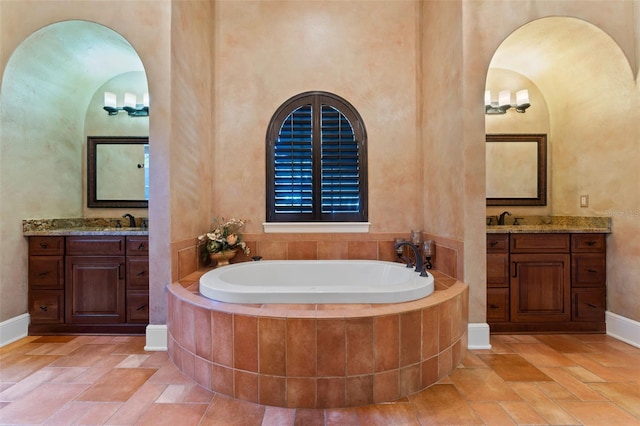 bathroom with a relaxing tiled tub, a high ceiling, and vanity