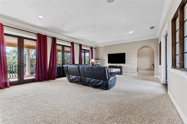 carpeted living room with french doors and crown molding