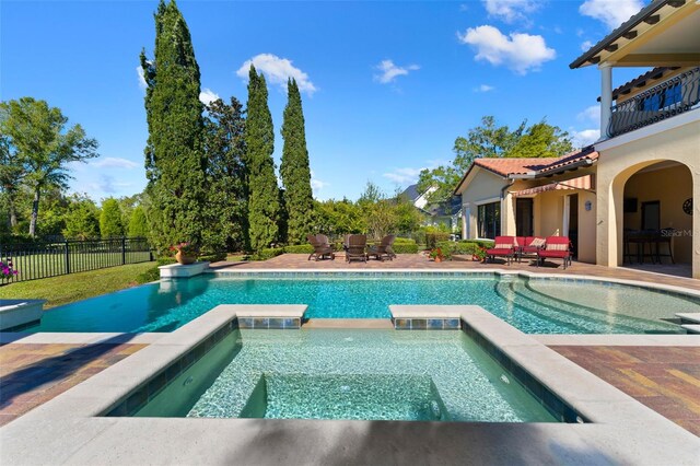 view of swimming pool with a patio area and an in ground hot tub