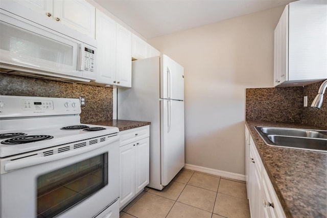 3206 W Azeele St Unit 100, Tampa, FL 33609 - kitchen with white appliances, a sink, dark countertops, white cabinetry, and tasteful backsplash