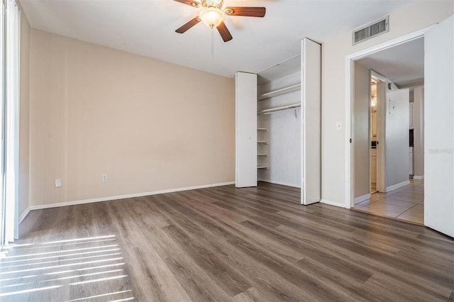 unfurnished bedroom with ceiling fan, a closet, and hardwood / wood-style flooring