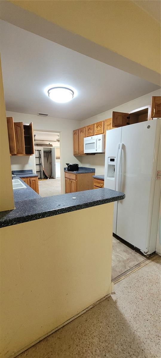 kitchen featuring kitchen peninsula, sink, and white appliances