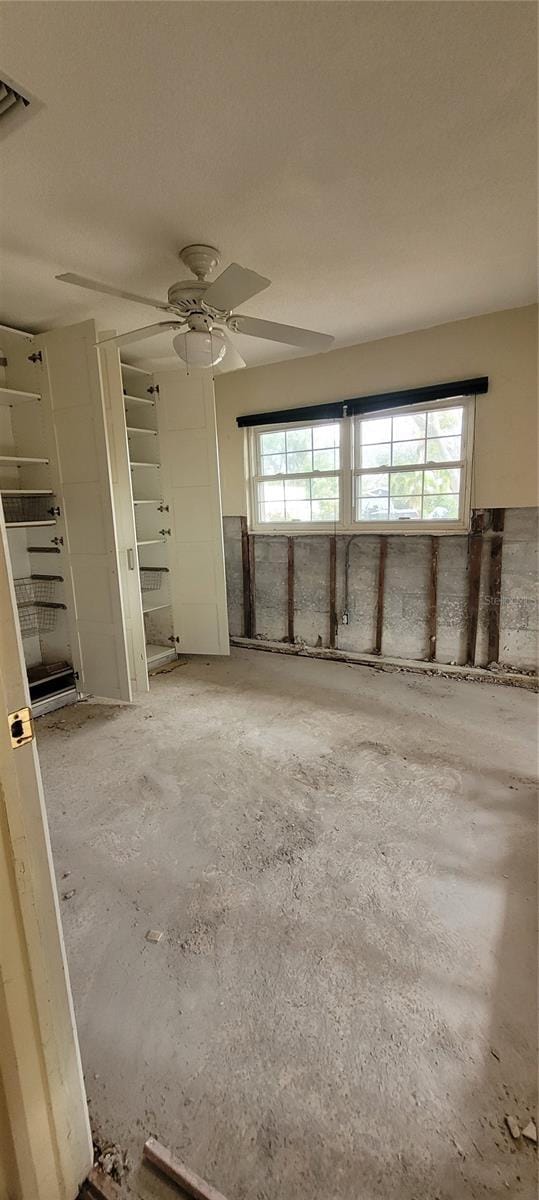 interior space with multiple windows, concrete flooring, and ceiling fan