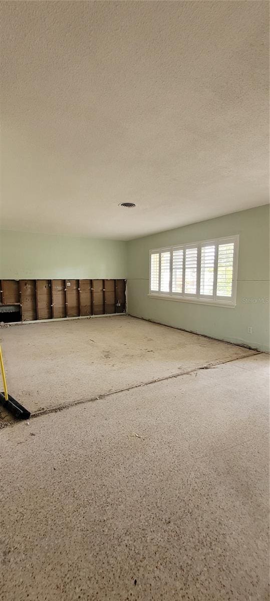 unfurnished room featuring a textured ceiling