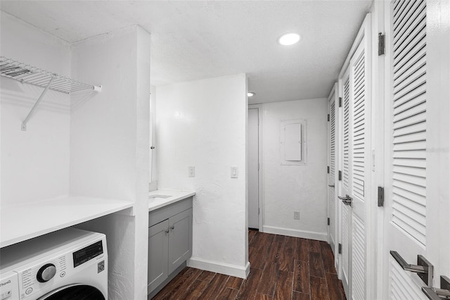 washroom with dark wood-type flooring, a textured ceiling, and washer / dryer