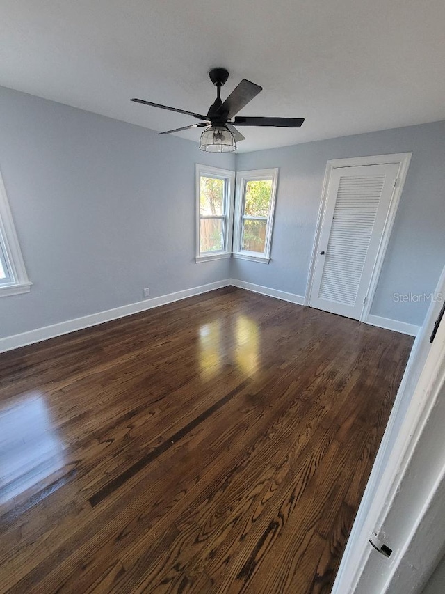 empty room featuring dark hardwood / wood-style flooring and ceiling fan