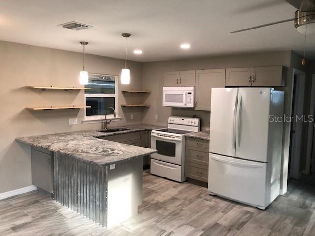 kitchen with gray cabinetry, light stone countertops, sink, kitchen peninsula, and white appliances