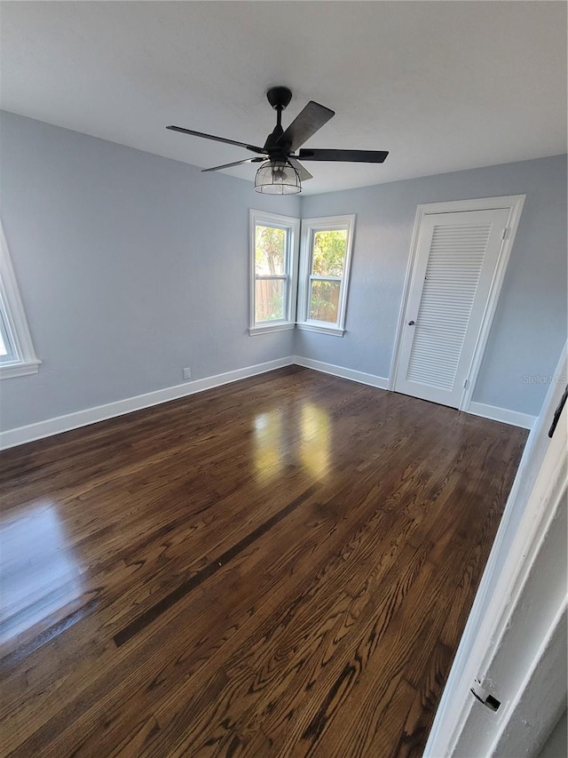 unfurnished room with ceiling fan and dark hardwood / wood-style floors