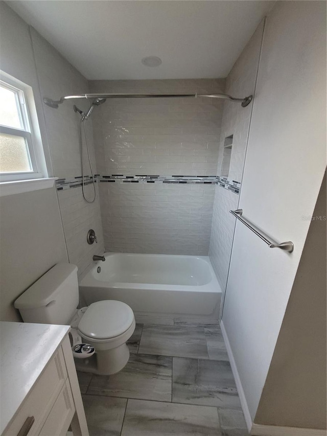 full bathroom featuring vanity, toilet, and tiled shower / bath combo