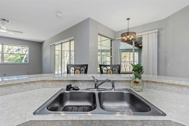 kitchen featuring pendant lighting, sink, and a chandelier