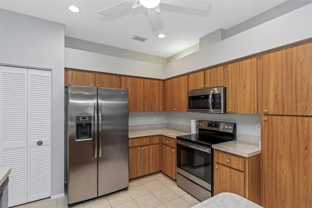 kitchen featuring ceiling fan, light tile patterned flooring, and stainless steel appliances