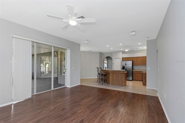 kitchen featuring ceiling fan, a center island, stainless steel refrigerator with ice dispenser, and light hardwood / wood-style flooring