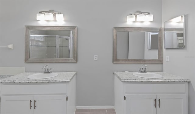 bathroom with tile patterned flooring, vanity, and walk in shower