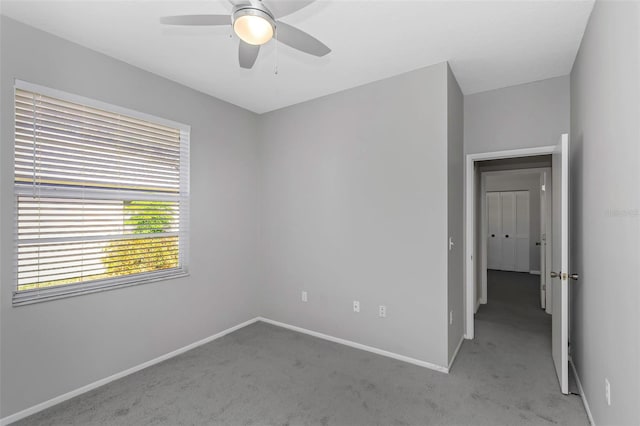 carpeted spare room with ceiling fan