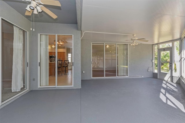 unfurnished sunroom featuring ceiling fan