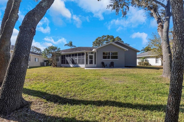 back of house featuring a patio, a lawn, and a sunroom