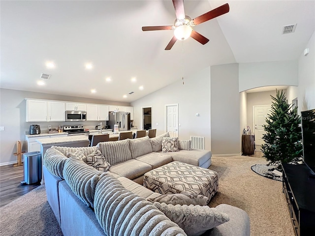 living room with hardwood / wood-style flooring, high vaulted ceiling, and ceiling fan