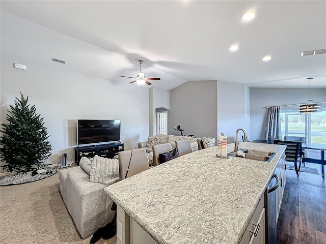 kitchen featuring sink, hardwood / wood-style floors, pendant lighting, vaulted ceiling, and a kitchen island with sink