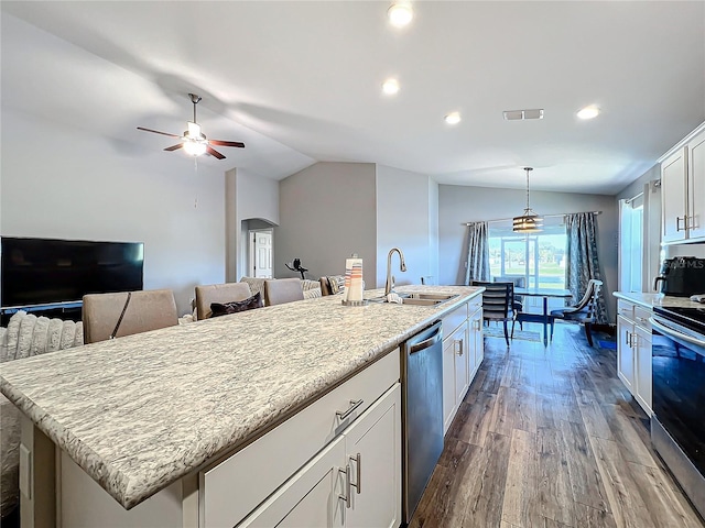 kitchen featuring decorative light fixtures, hardwood / wood-style floors, white cabinetry, lofted ceiling, and an island with sink