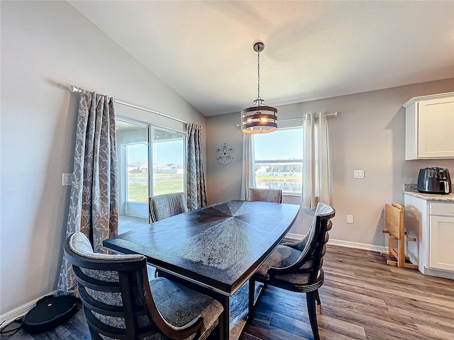 dining space with light hardwood / wood-style floors and vaulted ceiling