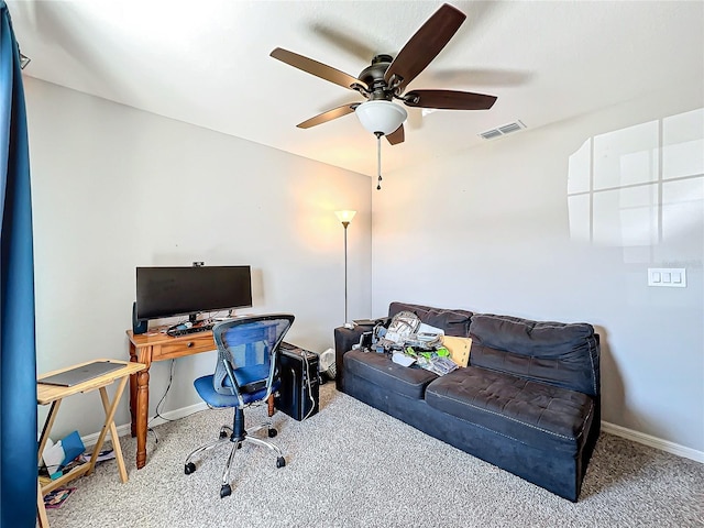 carpeted office space featuring ceiling fan