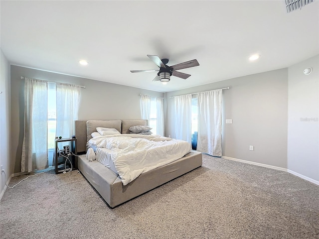 bedroom featuring multiple windows, carpet flooring, and ceiling fan