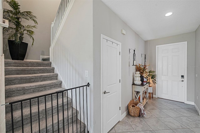 entryway with light tile patterned floors and a textured ceiling