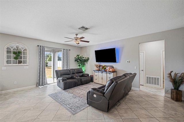 living room with a textured ceiling, ceiling fan, and light tile patterned flooring