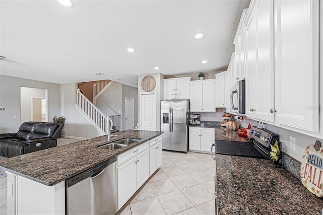 kitchen with sink, white cabinets, dark stone counters, and appliances with stainless steel finishes