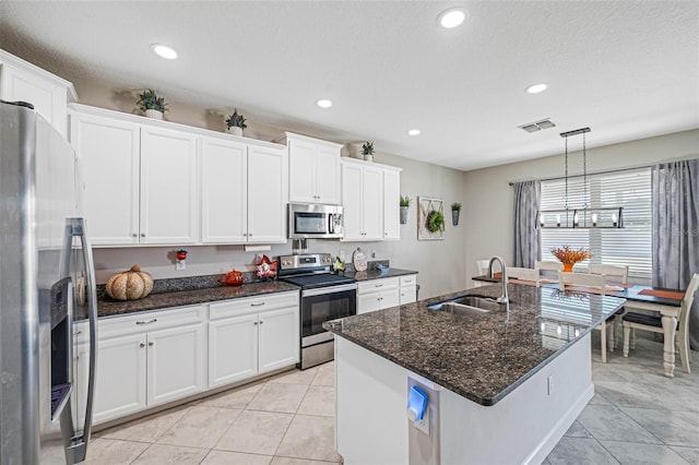 kitchen featuring decorative light fixtures, white cabinetry, sink, and appliances with stainless steel finishes