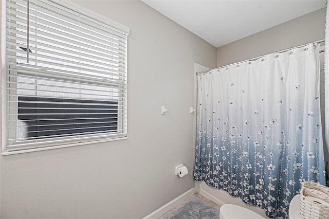 bathroom with a shower with curtain and toilet