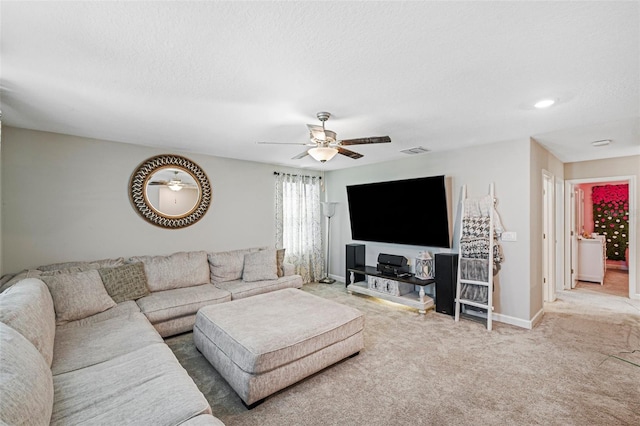 living room featuring carpet flooring, ceiling fan, and a textured ceiling