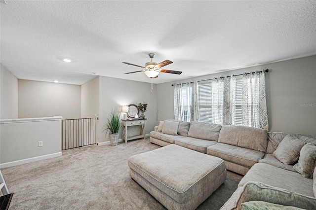 living room featuring carpet flooring, a textured ceiling, and ceiling fan