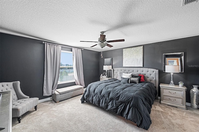 bedroom with a textured ceiling, ceiling fan, and light carpet