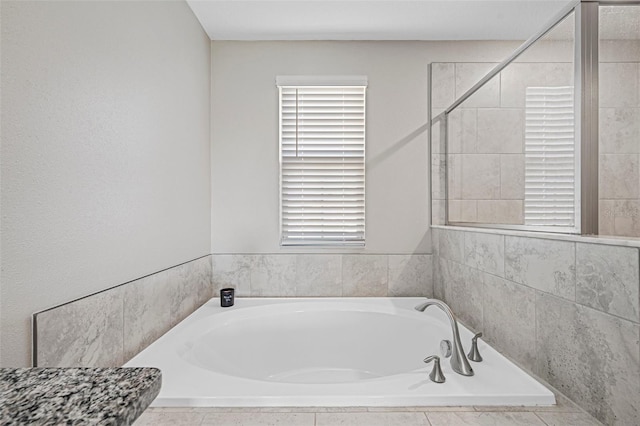 bathroom with a relaxing tiled tub