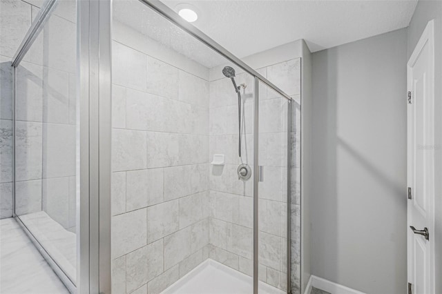 bathroom with a textured ceiling and an enclosed shower