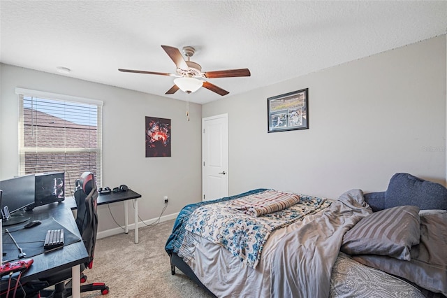 carpeted bedroom with ceiling fan and a textured ceiling