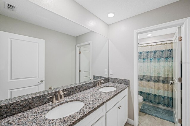 full bathroom featuring tile patterned flooring, shower / bath combination with curtain, vanity, and toilet